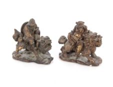 A pair of Chinese bronze scroll weights in the form of figures riding Fo dogs, 8cm long x 7cm high