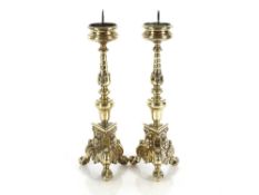 A pair of 19th Century ecclesiastical brass pricket candlesticks, raised on three claw and ball