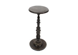 A 19th Century carved ebonised plant stand, circular top raised on acanthus baluster column and