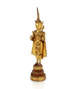 A small antique Thai gilt bronze standing Buddha 19.5cm high; and a small antique gilded copper dish