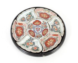 An Imari pattern seven piece hors d'oeuvres set contained in a circular lacquered tray, 34cm dia.