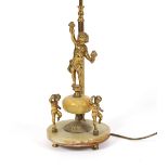 An onyx and gilt metal table lamp, with cherub decoration and red silk tasselled shade, 73cm high