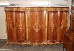 A large and unusual French marquetry and gilt decorated quadruple wardrobe of serpentine form,