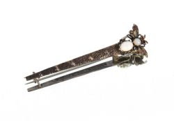 A white metal bar brooch, with insect decoration, inset opals and rubies in fitted case by