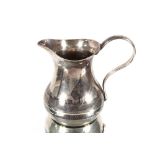 A small Eastern white metal baluster cream jug, having Niello ware style decoration depicting scenic