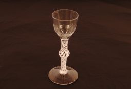 An 18th Century English drinking glass, having tulip shaped bowl above cotton twist baluster
