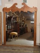 A large 19th Century stripped pine wall mirror, having scrolled arched pediment, 180cm x 153cm