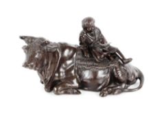 A 19th Century Japanese bronze model of a reclining bull, a child reading a book sat upon its