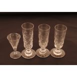 Three 19th Century drinking glasses with thumb press decoration, on circular stepped bases; and a