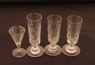 Three 19th Century drinking glasses with thumb press decoration, on circular stepped bases; and a