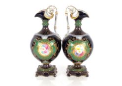A pair of Sevres style ewers, having floral spray decorated central panels on apple green and cobalt