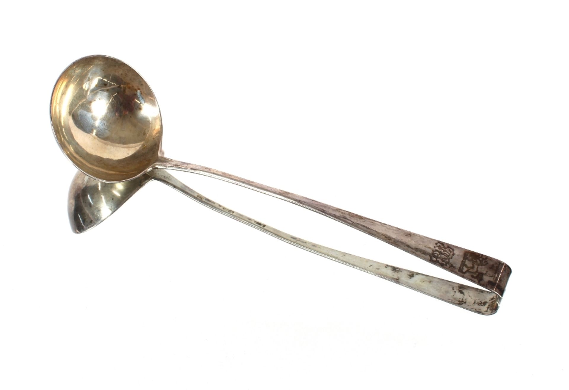 A George III silver soup ladle, with scroll handle decorated monogram and family crest marks