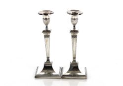 A pair of George III Adam design candlesticks, the urn shaped sconces raised on tapering square