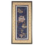 A framed and glazed Chinese embroidered section of a mandarin's cloak, decorated flowers and