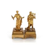 A pair of Ormolu figures depicting musicians, raised on square stepped leaf bordered bases