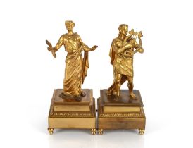 A pair of Ormolu figures depicting musicians, raised on square stepped leaf bordered bases