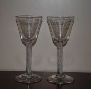 Two antique drinking glasses, having tapering bowls, spiral twist stems and circular spread feet