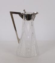 An antique cut glass and silver mounted claret jug