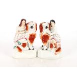 An unusual pair of 19th Century Staffordshire spaniels with children on their backs, 17cm high