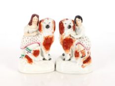 An unusual pair of 19th Century Staffordshire spaniels with children on their backs, 17cm high