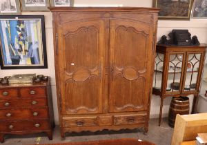 A large oak French armoire, with interior shelf and hanging compartment, two long drawers below