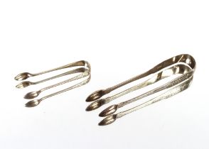 A pair of Georgian silver bright cut sugar tongs and a smaller pair; and a George III silver