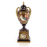 A late 19th Century Vienna porcelain vase on plinth, decorated with an oval panel of maidens and