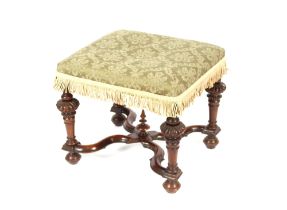 A William & Mary style walnut framed footstool, the top upholstered in green floral Damask, raised