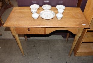 An early 20th Century golden oak desk, fitted single drop flap compartment and raised on rounded