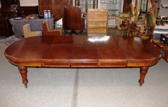 A large Victorian mahogany extending dining table, with three extra leaves raised on leaf carved and