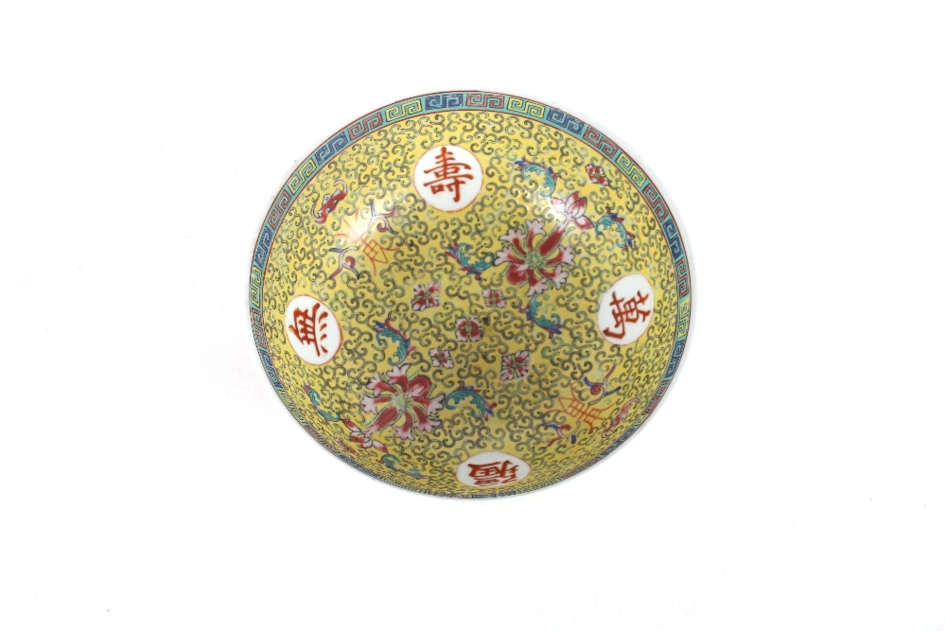 A Chinese yellow ground bowl, profusely decorated flowers and symbols within Greek key border, 22. - Image 2 of 3