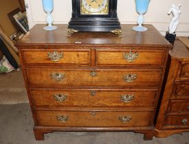 A George III oak and mahogany cross banded chest of two short and three long drawers, raised on