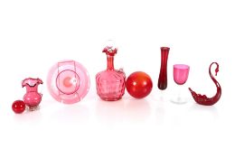 A cranberry glass claret jug, a cranberry glass beaker, various other cranberry glass items; a