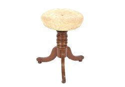 A late Victorian mahogany revolving piano stool, raised on a ring turned baluster column and