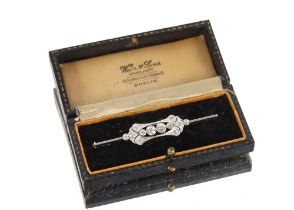 A diamond brooch in white metal mount, set with two 0.25 carat diamonds surrounded with an