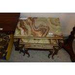 A nest of onyx and brass occasional tables