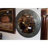 A circular pewter Arts & Crafts style convex wall