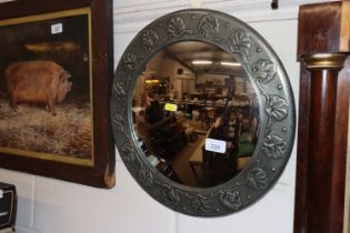 A circular pewter Arts & Crafts style convex wall