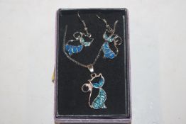 A blue enamel pendant in the form of a cat hung to