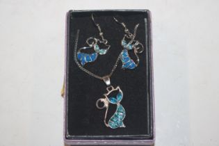 A blue enamel pendant in the form of a cat hung to