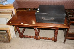 A good quality walnut coffee table raised on turne