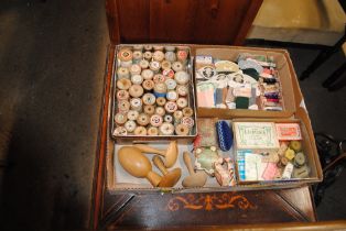 A tray containing various vintage sewing items to