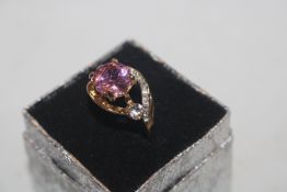A dress ring set with pink stone