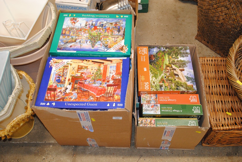 Two boxes of various jigsaw puzzles