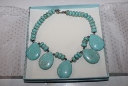 A boxed turquoise style necklace
