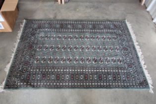 An approx 6' x 4' green patterned rug