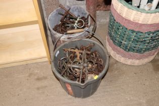 Two buckets containing various horse bits