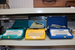 Three plastic portable typewriters