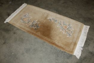 An approx 5'9" x 2'7" Chinese floral patterned rug