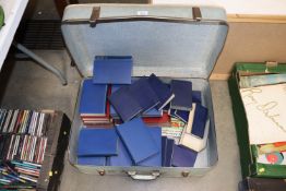 A suitcase and contents of books to include the Br